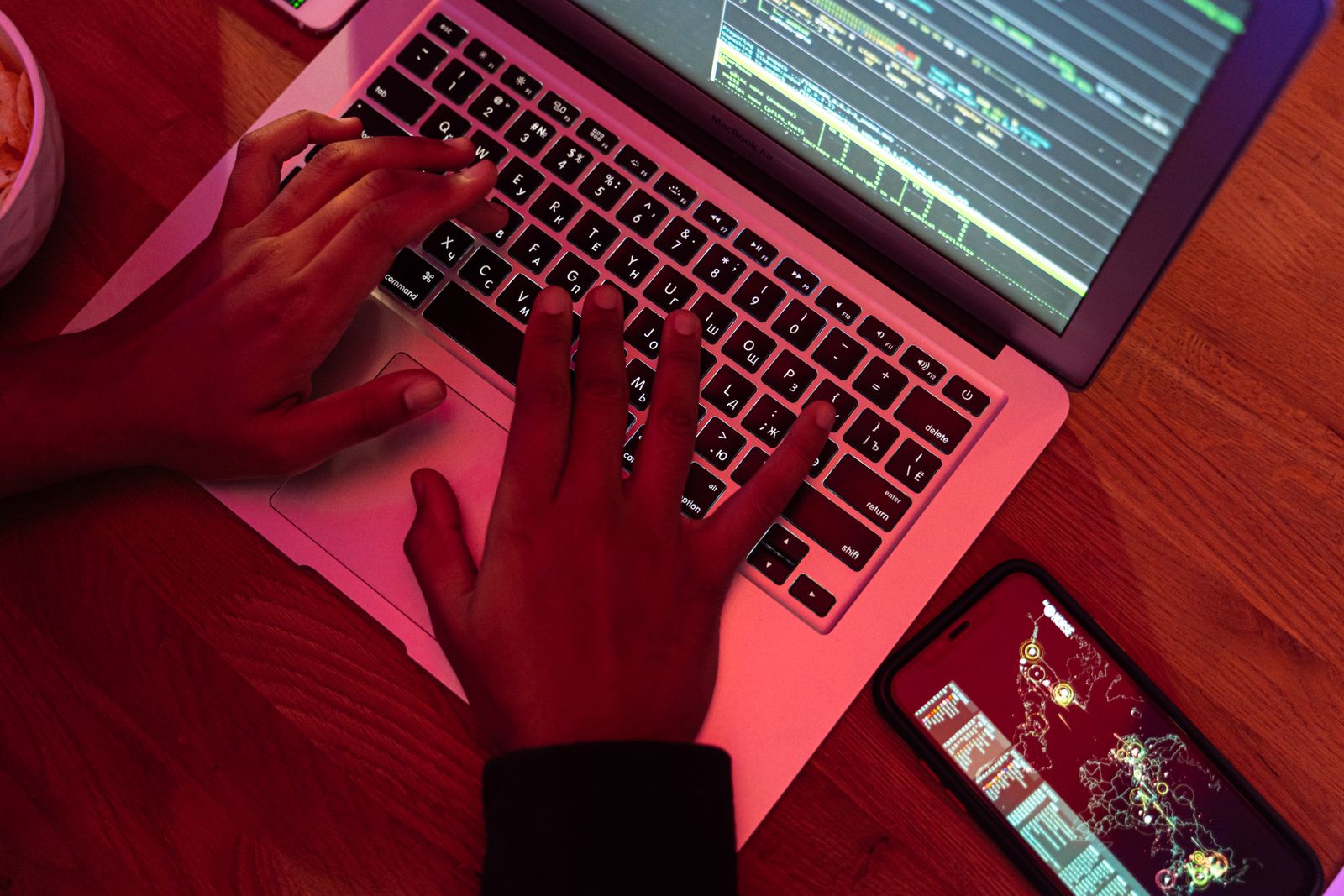 Hands typing code on a laptop late at night